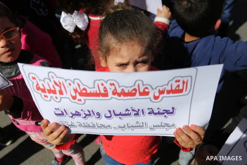 Palestinian children hold banners during a protest against U.S. President Donald Trump's decision to recognise Jerusalem as the capital of Israel, in front of the high commissioner for human rights headquarters, in Gaza...