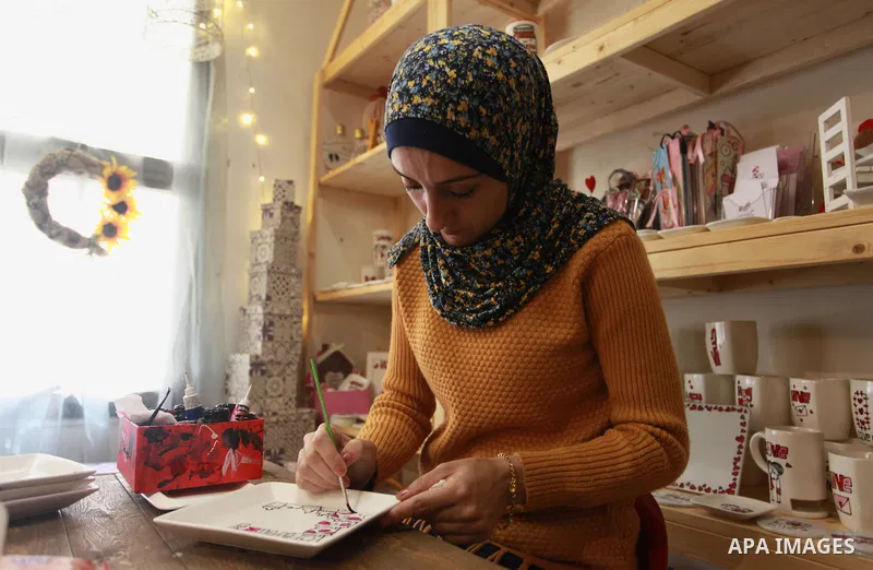 A Palestinian artist Dima Sha'sha'a "owner of Tezzkar Project" works at her shop in Gaza city on February 28, 2018. Dima and her brother Hamdi take the drawing on dishes, cardboard and glass as a job for nearly seven yea...