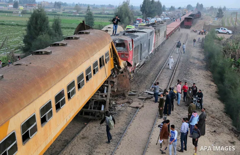 Egyptians gather at the scene of a train collision near Kom Hamadah, in the Beheira province in the Nile delta, Egypt on February 28, 2018. The death toll of the train crash that took place in Beheira province northern t...