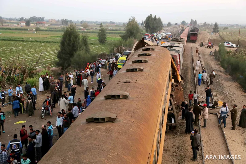 Egyptians gather at the scene of a train collision near Kom Hamadah, in the Beheira province in the Nile delta, Egypt on February 28, 2018. The death toll of the train crash that took place in Beheira province northern t...