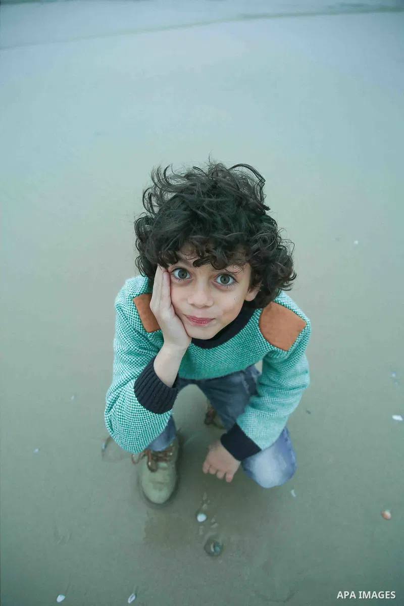 A boy with afro hairstyle have fun on the beach. Photo by Sanad Ltefa