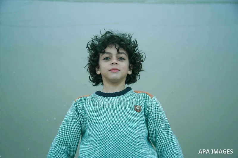 A boy with afro hairstyle have fun on the beach. Photo by Sanad Ltefa
