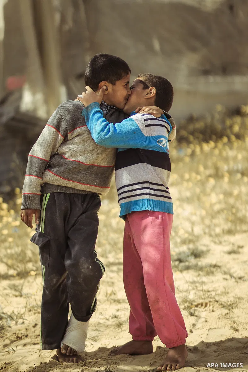 Two boys kiss each other. Photo by Sanad Ltefa