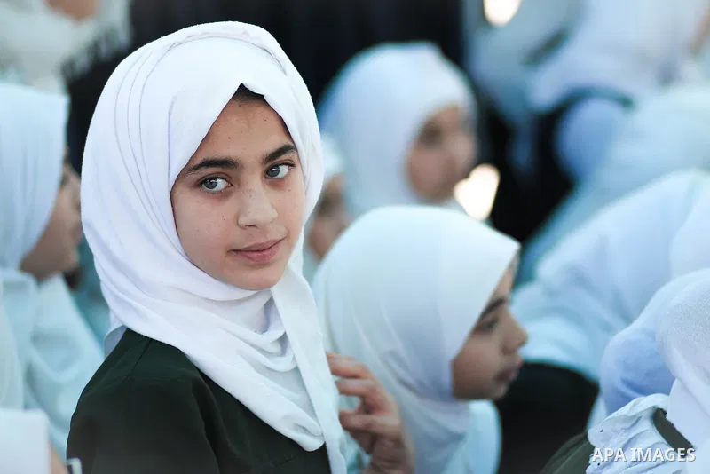 A school girl wearing veil with green eyes and ambitious look. Photo by Sanad Ltefa