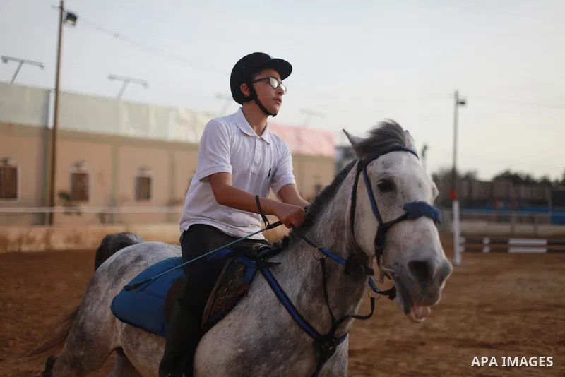 A Palestinian boy rides his horse during a local jumping competition "friends challenge" in Gaza city on March 2, 2018. Photo by Mahmoud Ajour