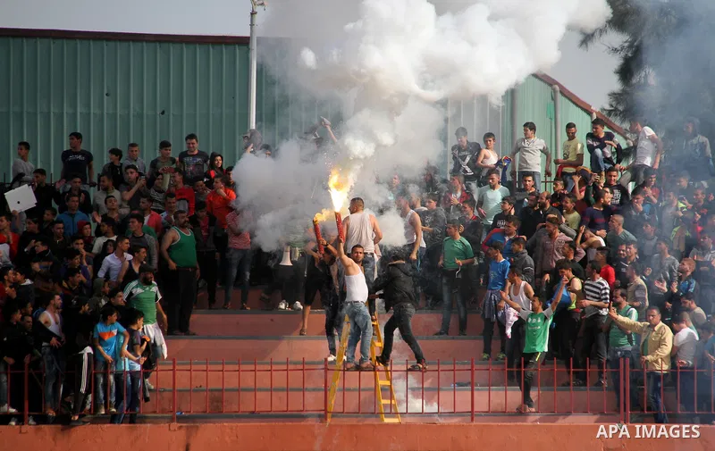 Palestinian fans light flares during a a football match between Palestinian Shabab Rafah football club players (in blue) and Shejaiya's football club players (in green) at Palestine Stadium in Gaza city on March 4, 2018....