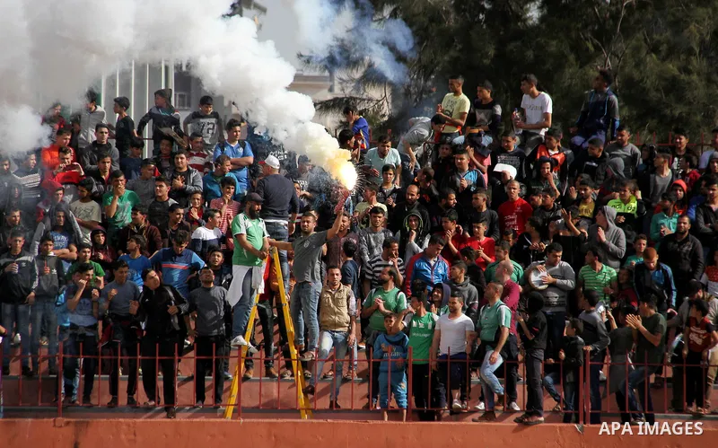 Palestinian fans light flares during a a football match between Palestinian Shabab Rafah football club players (in blue) and Shejaiya's football club players (in green) at Palestine Stadium in Gaza city on March 4, 2018....