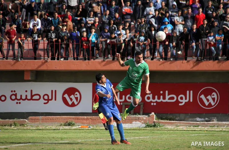 Palestinian Shabab Rafah football club players (in blue) and Shejaiya's football club players (in green) compete during a football match at Palestine Stadium in Gaza city on March 4, 2018. Photo by Mahmoud Ajour