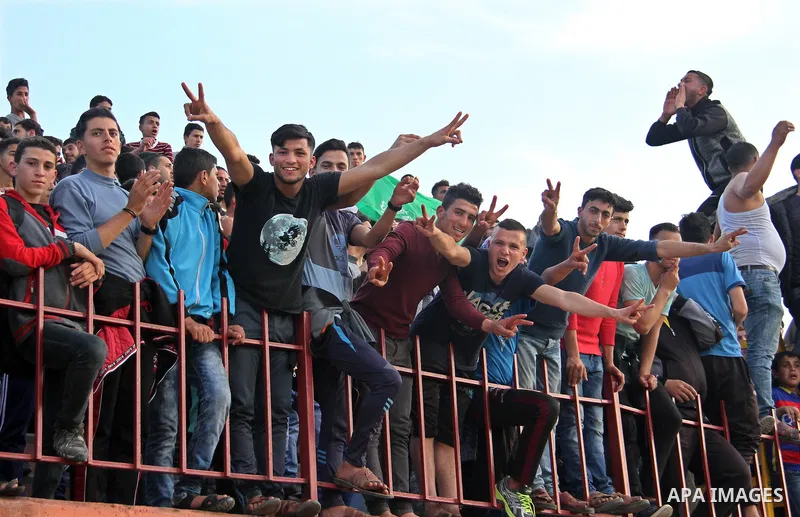 Palestinian fans attend a a football match between Palestinian Shabab Rafah football club players (in blue) and Shejaiya's football club players (in green) at Palestine Stadium in Gaza city on March 4, 2018. Photo by Mah...