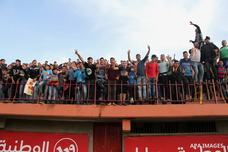 Palestinian fans attend a a football match between Palestinian Shabab Rafah football club players (in blue) and Shejaiya's football club players (in green) at Palestine Stadium in Gaza city on March 4, 2018. Photo by Mah...
