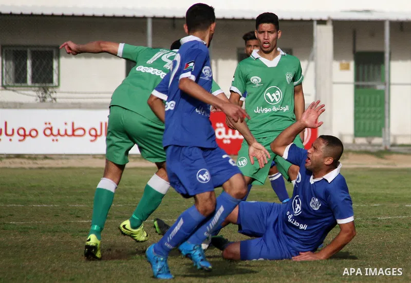 Palestinian Shabab Rafah football club players (in blue) and Shejaiya's football club players (in green) compete during a football match at Palestine Stadium in Gaza city on March 4, 2018. Photo by Mahmoud Ajour