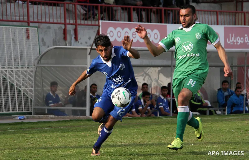 Palestinian Shabab Rafah football club players (in blue) and Shejaiya's football club players (in green) compete during a football match at Palestine Stadium in Gaza city on March 4, 2018. Photo by Mahmoud Ajour