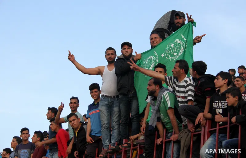 Palestinian fans attend a a football match between Palestinian Shabab Rafah football club players (in blue) and Shejaiya's football club players (in green) at Palestine Stadium in Gaza city on March 4, 2018. Photo by Mah...
