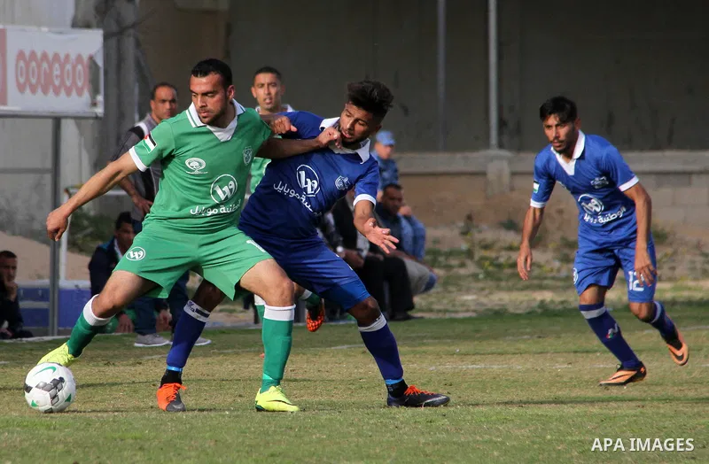 Palestinian Shabab Rafah football club players (in blue) and Shejaiya's football club players (in green) compete during a football match at Palestine Stadium in Gaza city on March 4, 2018. Photo by Mahmoud Ajour