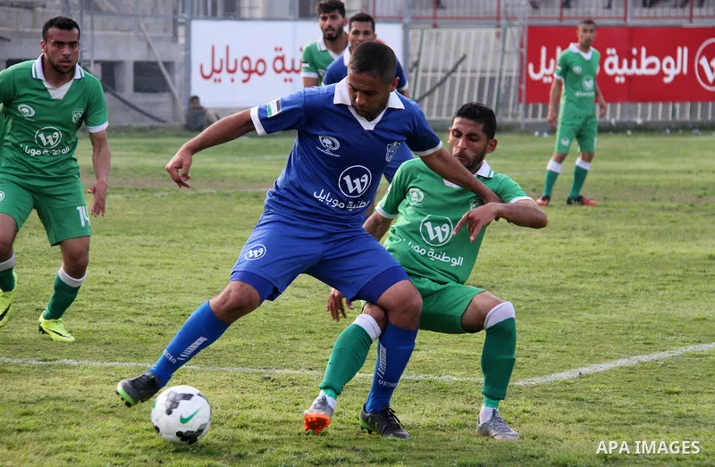 Palestinian Shabab Rafah football club players (in blue) and Shejaiya's football club players (in green) compete during a football match at Palestine Stadium in Gaza city on March 4, 2018. Photo by Mahmoud Ajour