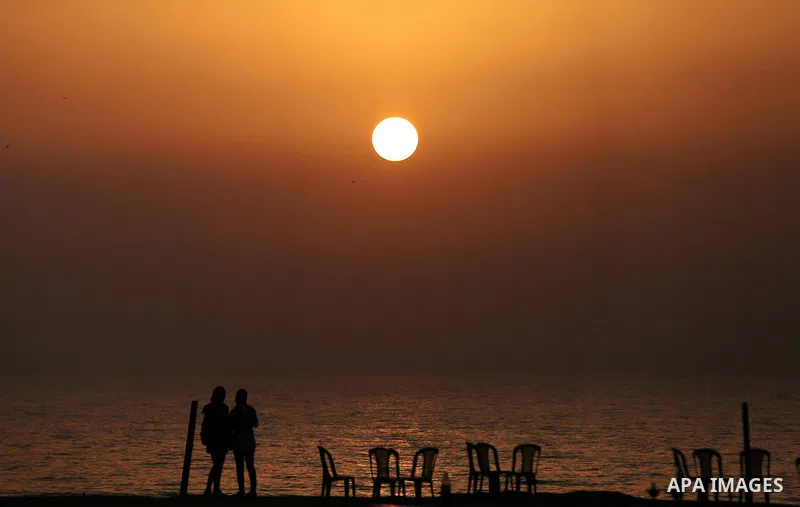 Palestinian girls stand on the beach of Gaza city during sunset on March 5, 2018. Photo by Yasser Qudih