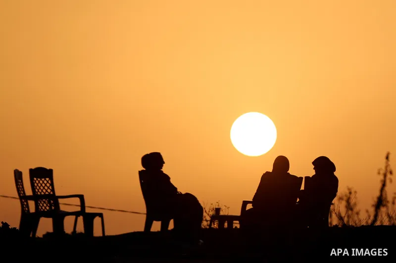 Palestinian women sit on the beach of Gaza city during sunset on March 5, 2018. Photo by Yasser Qudih
