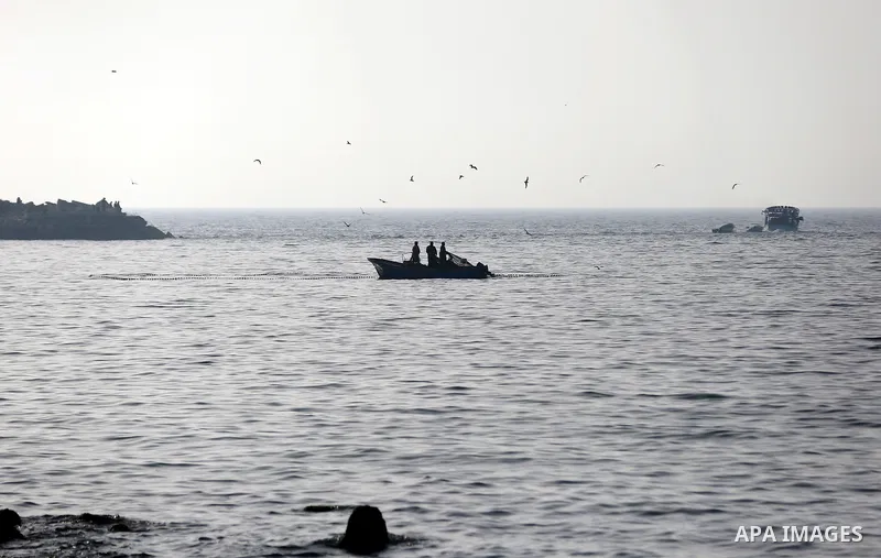 Palestinian fishermen ride their boat in the sea of Gaza city during sunset on March 5, 2018. Photo by Yasser Qudih
