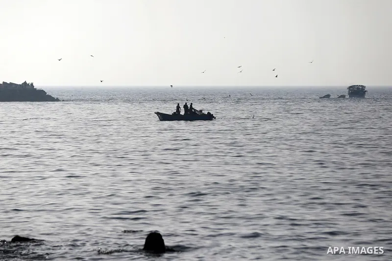Palestinian fishermen ride their boat in the sea of Gaza city during sunset on March 5, 2018. Photo by Yasser Qudih