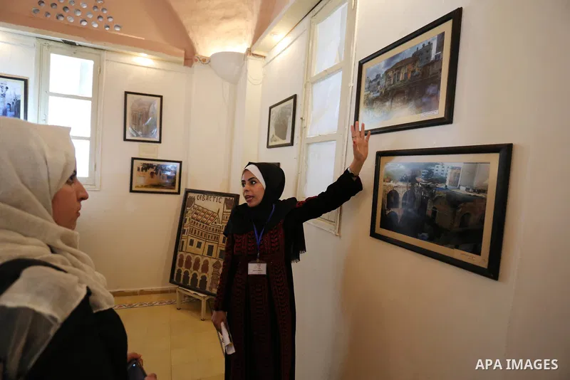 Palestinians attend exhibition of photographs for antique sites in Gaza city, on March 6, 2018. Photo by Ashraf Amra