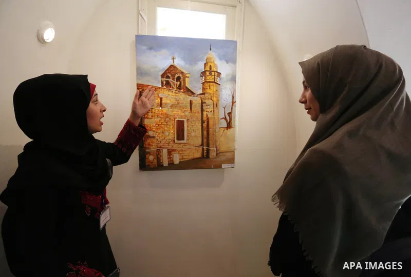 Palestinians attend exhibition of photographs for antique sites in Gaza city, on March 6, 2018. Photo by Ashraf Amra