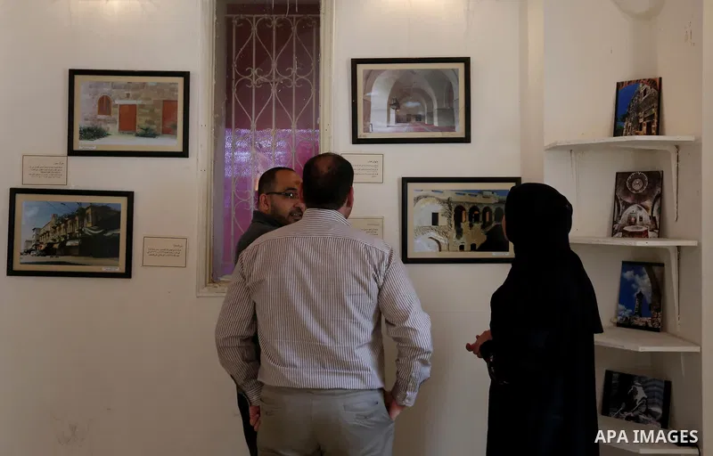Palestinians attend exhibition of photographs for antique sites in Gaza city, on March 6, 2018. Photo by Ashraf Amra
