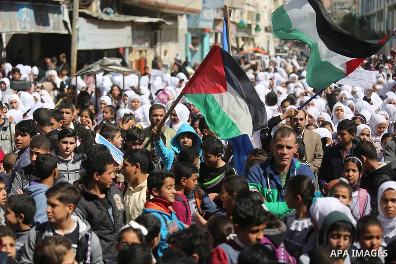 Palestinian school students shout slogans and hold placards in a protest against the US move to freeze funding for the UN agency for Palestinian refugees on March 7, 2018 at the al-Nusairat refugee camp, in central Gaza...