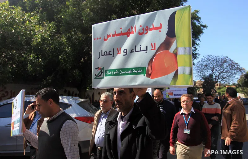 Palestinian engineers hold banners during a protest against the UNRWA decision to reduce of the work contracts in Gaza city, March 7, 2018. Photo by Mahmoud Ajour