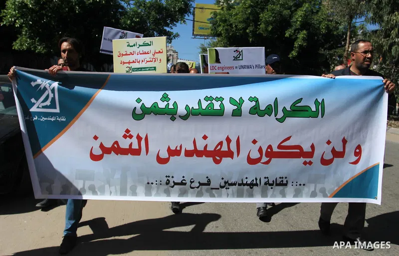 Palestinian engineers hold banners during a protest against the UNRWA decision to reduce of the work contracts in Gaza city, March 7, 2018. Photo by Mahmoud Ajour