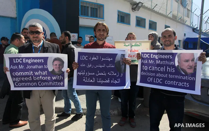 Palestinian engineers hold banners during a protest against the UNRWA decision to reduce of the work contracts in Gaza city, March 7, 2018. Photo by Mahmoud Ajour