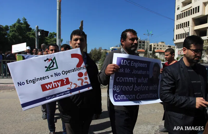 Palestinian engineers hold banners during a protest against the UNRWA decision to reduce of the work contracts in Gaza city, March 7, 2018. Photo by Mahmoud Ajour