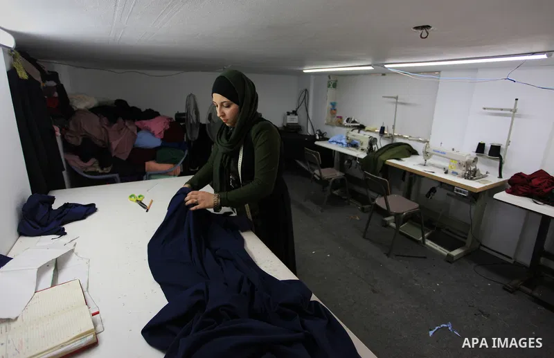 Amina Hamo, 25, a Palestinian fashion designer works on dresses at her shop on the occasion of International Women's Day, in Gaza city, on March 8, 2018. International Women’s Day is annually held on March 8 to celebrate...