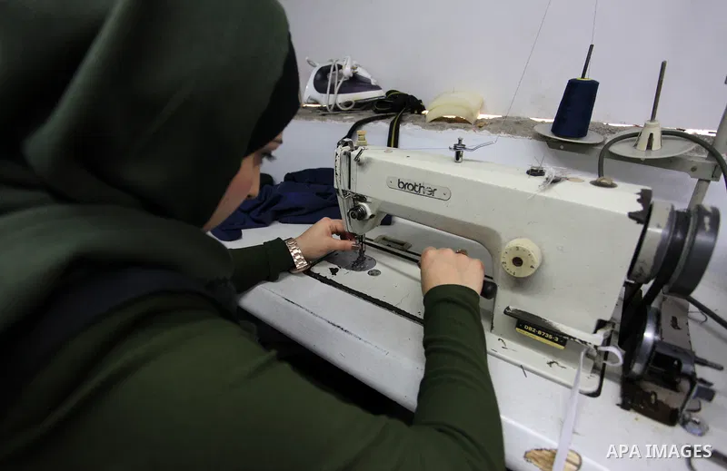 Amina Hamo, 25, a Palestinian fashion designer works on dresses at her shop on the occasion of International Women's Day, in Gaza city, on March 8, 2018. International Women’s Day is annually held on March 8 to celebrate...