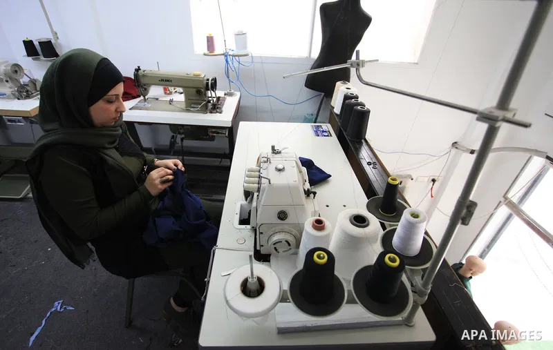Amina Hamo, 25, a Palestinian fashion designer works on dresses at her shop on the occasion of International Women's Day, in Gaza city, on March 8, 2018. International Women’s Day is annually held on March 8 to celebrate...
