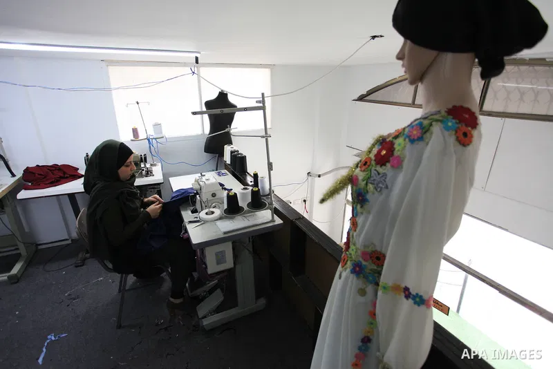 Amina Hamo, 25, a Palestinian fashion designer works on dresses at her shop on the occasion of International Women's Day, in Gaza city, on March 8, 2018. International Women’s Day is annually held on March 8 to celebrate...