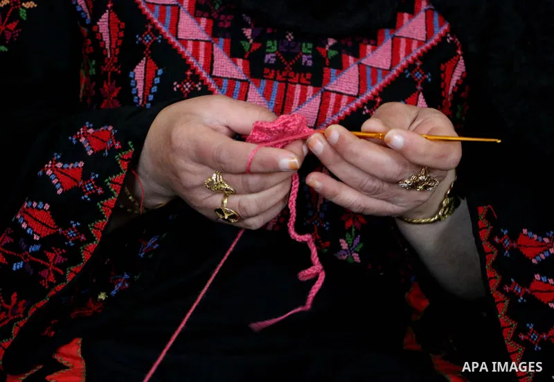 Jihad Awad, 50, a Palestinian woman of special needs, works on embroidery on the occasion of International Women's Day, in al-Bureij refugee camp, in the center of Gaza strip, on March 8, 2018. International Women’s Day...