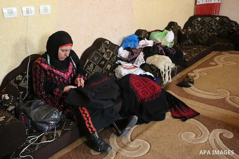 Jihad Awad, 50, a Palestinian woman of special needs, works on embroidery on the occasion of International Women's Day, in al-Bureij refugee camp, in the center of Gaza strip, on March 8, 2018. International Women’s Day...