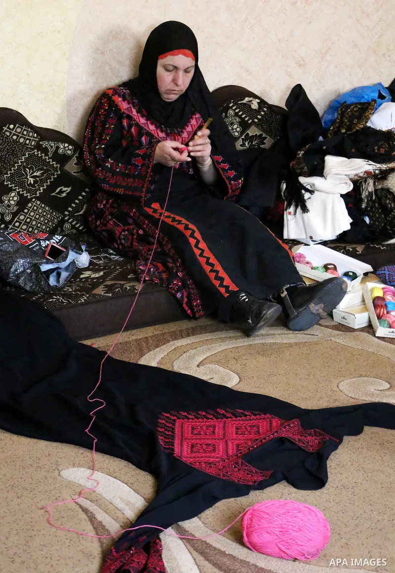 Jihad Awad, 50, a Palestinian woman of special needs, works on embroidery on the occasion of International Women's Day, in al-Bureij refugee camp, in the center of Gaza strip, on March 8, 2018. International Women’s Day...