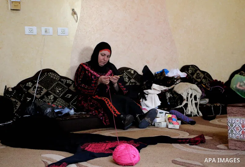 Jihad Awad, 50, a Palestinian woman of special needs, works on embroidery on the occasion of International Women's Day, in al-Bureij refugee camp, in the center of Gaza strip, on March 8, 2018. International Women’s Day...
