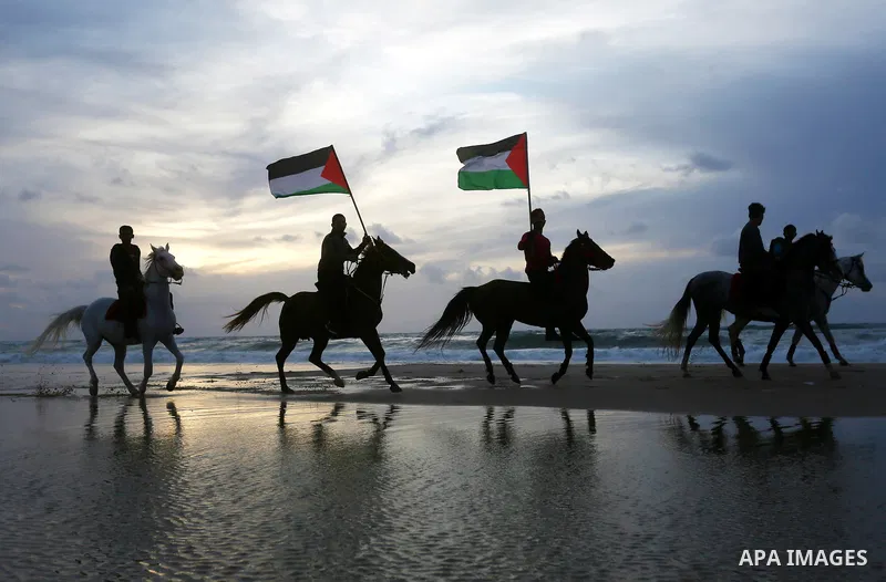 Palestinians perform with horses during an equestrian show by the beach in Gaza City on March 9, 2018. Photo by Ashraf Amra