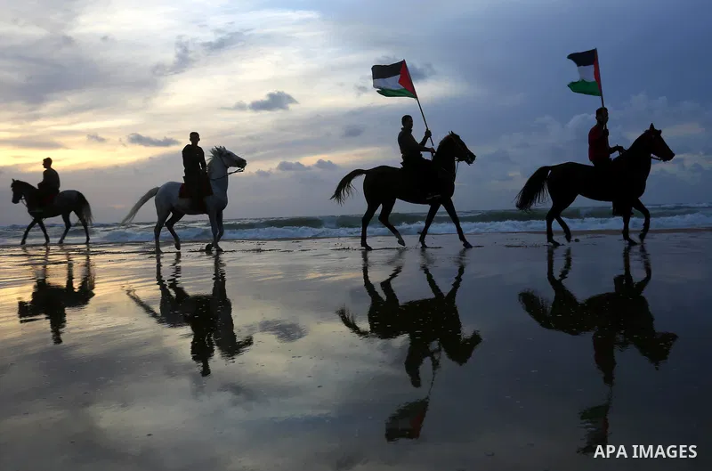 Palestinians perform with horses during an equestrian show by the beach in Gaza City on March 9, 2018. Photo by Ashraf Amra