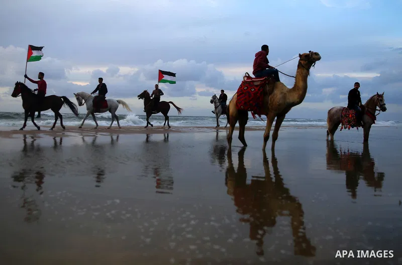 Palestinians perform with horses during an equestrian show by the beach in Gaza City on March 9, 2018. Photo by Ashraf Amra