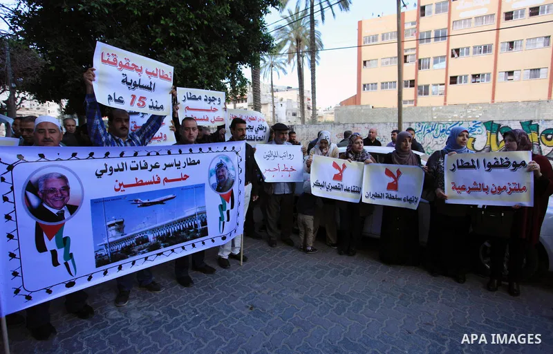 Palestinian employees of Gaza Airport hold banners during a protest demanding their rights, in Gaza city on March 11, 2018. Photo by Mahmoud Ajour