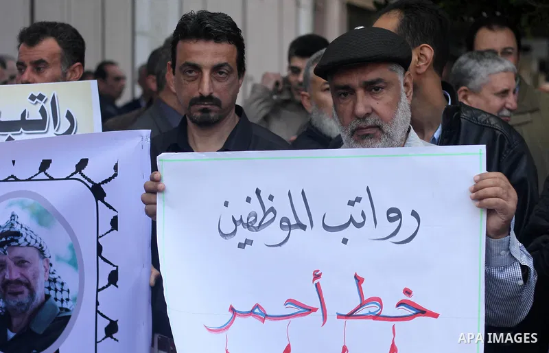 Palestinian employees of Gaza Airport hold banners during a protest demanding their rights, in Gaza city on March 11, 2018. Photo by Mahmoud Ajour