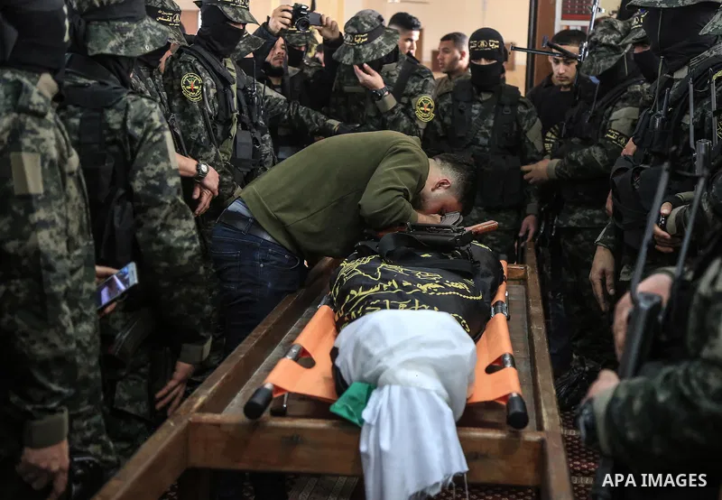 Palestinian militants from the Al-Quds Brigades, the armed wing of the Islamic Jihad movement mourn over the body of their comrade Ibrahim Farhat, 29, who was died yesterday in an explosion during his funeral in Beit lah...