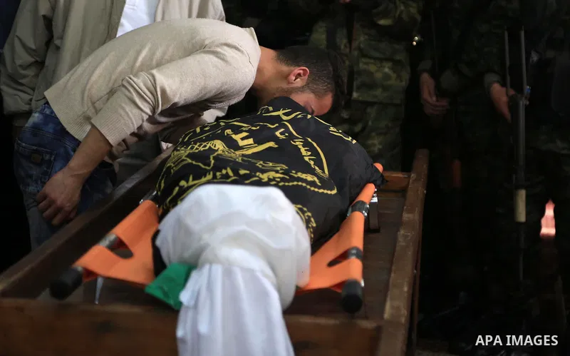 Palestinian militants from the Al-Quds Brigades, the armed wing of the Islamic Jihad movement mourn over the body of their comrade Ibrahim Farhat, 29, who was died yesterday in an explosion during his funeral in Beit lah...