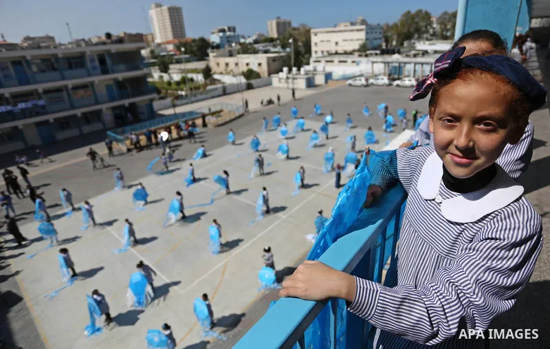 Palestinian schoolgirls fly kites during a protest against US aid cuts to mark the seventh anniversary of the Tohoku earthquake and tsunami that left more than 18,500 people dead or missing, at a school belonging to the...