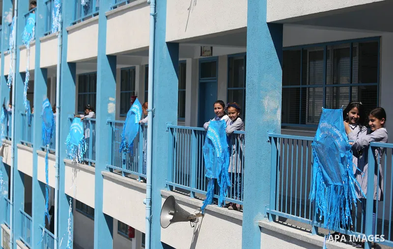 Palestinian schoolgirls fly kites during a protest against US aid cuts to mark the seventh anniversary of the Tohoku earthquake and tsunami that left more than 18,500 people dead or missing, at a school belonging to the...