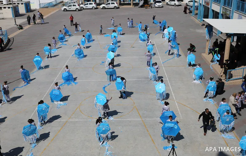 Palestinian schoolgirls fly kites during a protest against US aid cuts to mark the seventh anniversary of the Tohoku earthquake and tsunami that left more than 18,500 people dead or missing, at a school belonging to the...