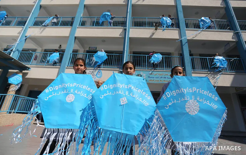 Palestinian schoolgirls fly kites during a protest against US aid cuts to mark the seventh anniversary of the Tohoku earthquake and tsunami that left more than 18,500 people dead or missing, at a school belonging to the...